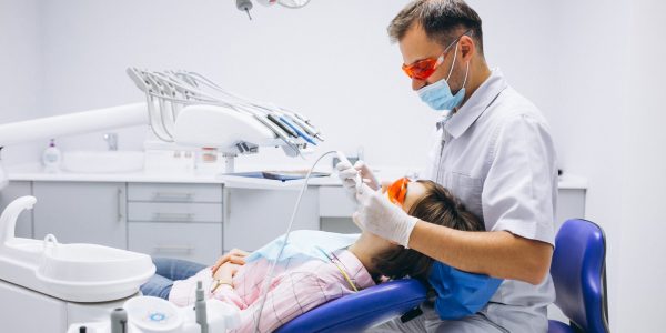 a dentist is checking a lady's teeth