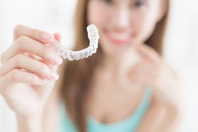 a lady is showing invisalign before putting on her teeth