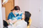 a dentist is cleaning a patient's teeth