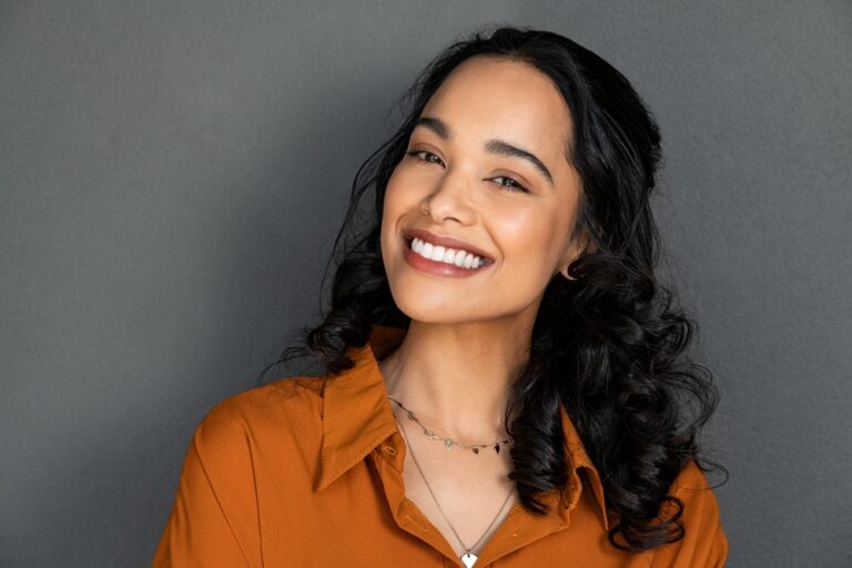 a lady is smiling after geeting teeth whitening treatment