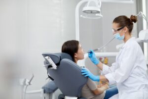 a lady dentist is examine a patient's teeth